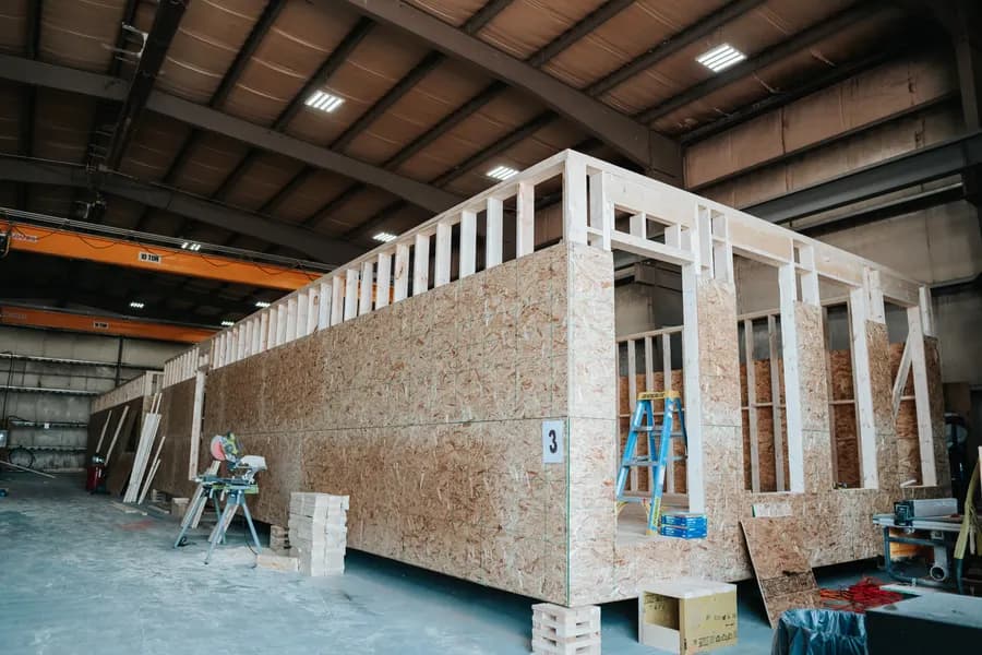 A full Herauf module sheathed in OSB on cribbing inside the plant, under the ten-tonne gantry crane rail