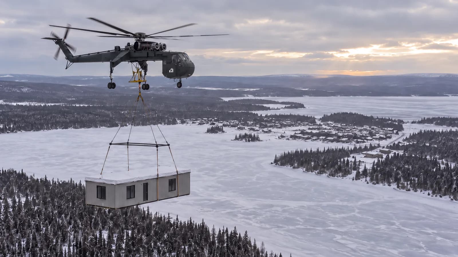A helicopter carrying a Herauf module over a frozen lake and boreal forest, AI-assisted visualization