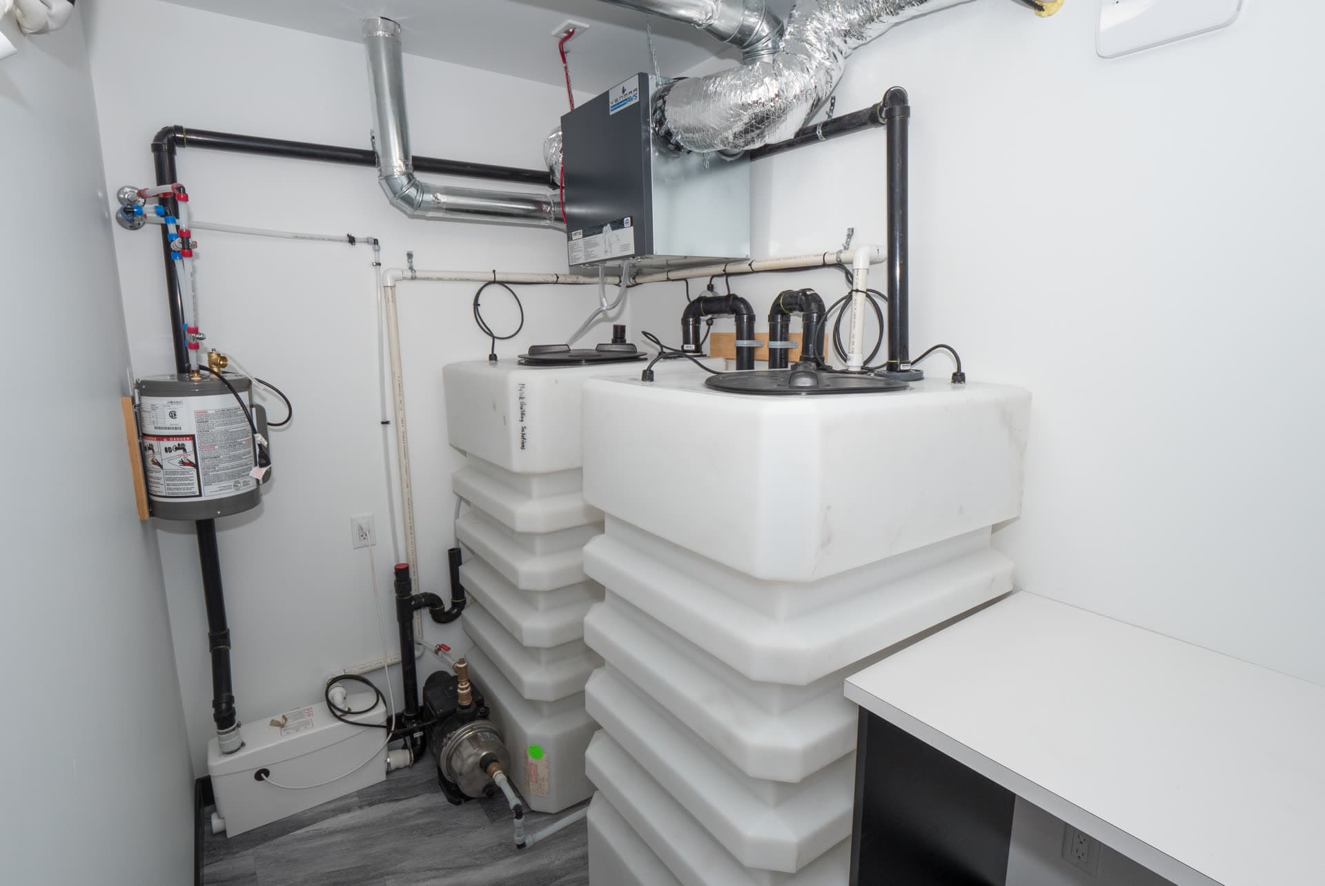 The utility room inside a Herauf unit: onboard water tanks, pump, water heater, heat-recovery ventilator
