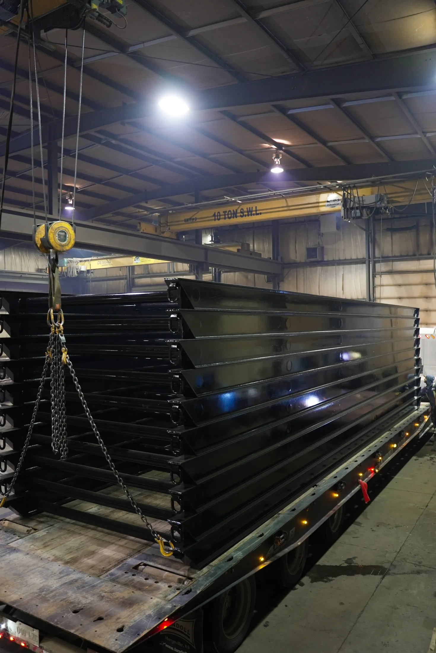 Engineered steel skids stacked on a flatbed trailer inside the Herauf plant, ready to ship