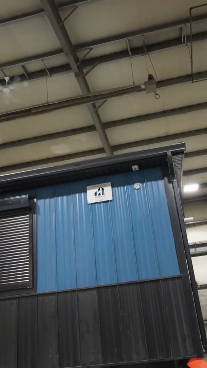 Blue-clad module under construction beneath the plant's steel roof trusses